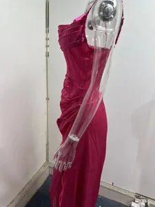 Detail of fuchsia satin ruched evening dress with side slit and spaghetti straps.