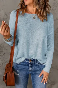 Detail showing the light blue knit texture and relaxed fit of the long sleeve sweater
