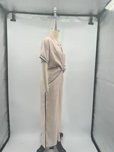 Profilo laterale di un elegante abito lungo rosa stile bohémien con bordi neri su manichino