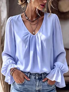 Close-up of elegant V-neck pleated blouse with flared ruffle cuffs in light blue