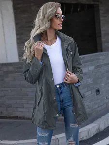 Stylish side view of a woman wearing an olive green mid-length hooded raincoat jacket