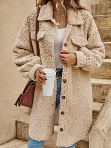 Detalle de abrigo largo de borreguillo beige con botones y bolsillos al aire libre.