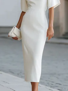 Dettaglio dell'elegante abito midi bianco aderente che mostra il tessuto di pregio