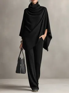 Full view of women's black knit two-piece set featuring a poncho top and wide-leg pants.