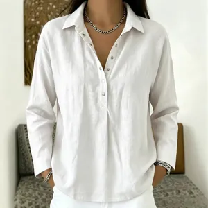 Detail view of a white linen long-sleeved button-up shirt with loose fit on a model