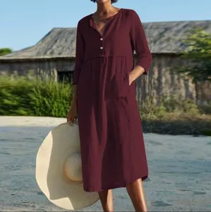 Casual burgundy cotton linen midi dress with buttons and pockets shown in outdoor setting