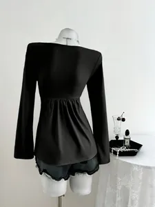 Vue arrière détaillée d'une élégante blouse noire à manches longues avec taille froncée chic.