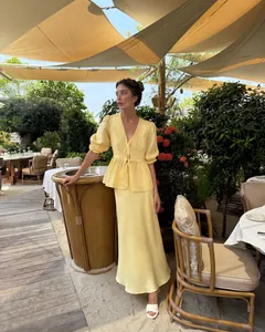 Elegant yellow two-piece summer set with bubble sleeves and maxi skirt in resort.