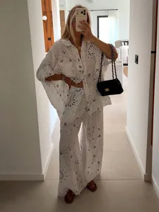Lässiges weißes Set aus bedrucktem Hemd mit Ösen und weiter Hose an einem Model