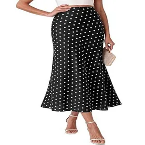 Showing the white polka dot pattern and the elegant trumpet hem of the midi skirt.