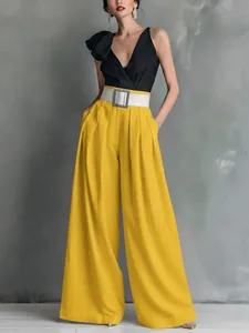 Elegante gelbe Weitbeinhose mit hoher Taille kombiniert mit einem schwarzen Top
