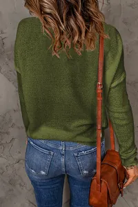 Back view detail of a woman wearing an olive green knit long sleeve sweater and blue jeans