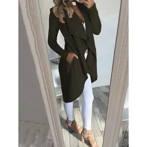 Donna che indossa un trench verde scuro con revers a cascata in un selfie allo specchio.