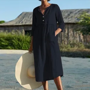 Detailed view of the navy blue cotton linen dress featuring button neckline and pockets