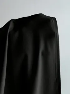 Gros plan sur le tissu noir de qualité et la double couture d'un haut décontracté femme