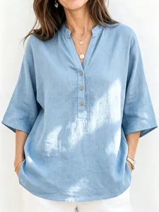 Detalle de blusa de lino azul claro con escote en V y botones de estilo madera