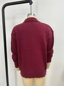 Back detail view of a solid color burgundy knitted cardigan sweater on mannequin.