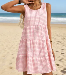 Detailansicht eines rosa-weiß karierten, ärmellosen, gestuften Minikleides am sonnigen Strand
