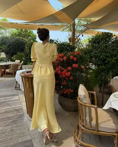 Elegant yellow puff sleeve peplum top and maxi skirt two-piece summer set back view.