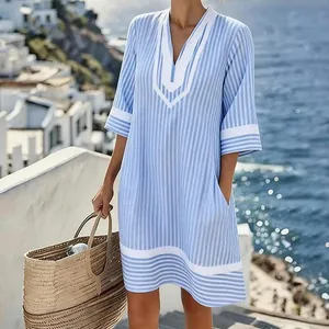 Casual blue and white striped V-neck beach dress captured in a coastal vacation setting