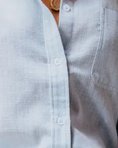 Primer plano que muestra la textura transpirable y los botones de esta camisa de lino azul