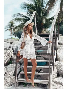 Model wearing white lace bikini cover up with deep V-neck and long sleeves on beach