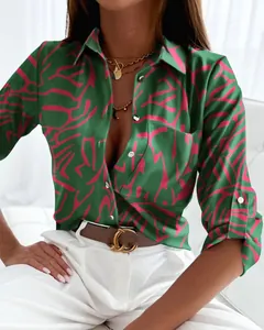 Dettaglio camicia da donna a maniche lunghe con stampa astratta rosa su tessuto di raso verde