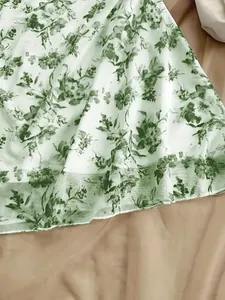 Dettaglio dell'orlo di un abito estivo a fiori verdi che mostra la trama del tessuto.