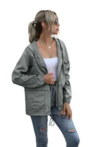 Detailed side view of a women's lightweight sage green hooded windbreaker jacket.