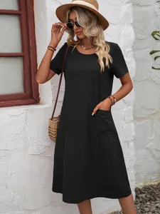 Détail d'une robe ample noire en coton et lin avec des poches et un col rond en extérieur.