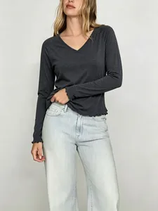 Détail d'un t-shirt gris anthracite à manches longues avec de jolis bords à volants