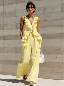 Full-length shot of a yellow ruffle V-neck cotton linen jumpsuit for resort wear.