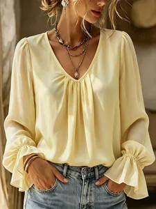 Detailed view of elegant light yellow V-neck pleated long sleeve blouse