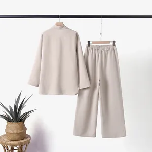 Minimalist beige two-piece lounge set with long sleeve shirt and wide leg trousers