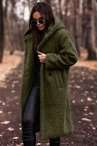 Outdoor lifestyle shot of a cozy olive green long teddy coat with soft autumn forest background