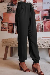 Detail van zwarte viscose harembroek met trekkoord in de elastische taille en zakken