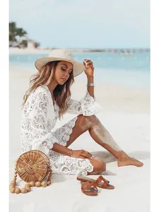 Elegant white floral lace V-neck beach cover-up dress shown in sunny beach setting