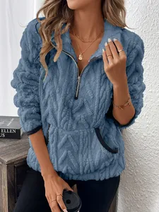 Détail du sweat à capuche en polaire bleue avec demi-fermeture éclair et texture