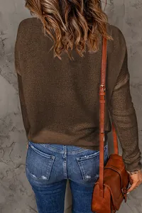 Back view of a casual brown long-sleeved knit sweater with jeans and a leather bag