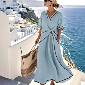 Elegante abito lungo bohémien azzurro con scollo a V e finiture nere al mare.