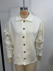 Close-up detail view of women's white knitted cardigan with buttons and lapel collar.