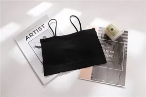 Black seamless bandeau top with spaghetti straps displayed on lifestyle magazines.