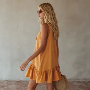 Side view of a mustard yellow sleeveless dress with a ruffled hem and a vintage vacation vibe