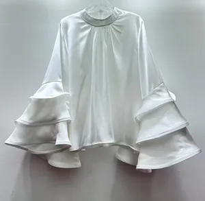 Elegant white satin blouse featuring dramatic and stylish multi-layered ruffle bell sleeves.