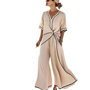 Elegante completo beige da donna con scollo a V e pantaloni a gamba larga con bordi neri