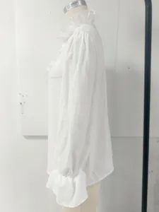 Detailed side view of a white vintage linen shirt with elegant ruffles on collar and cuffs