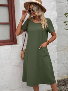 Détail d'une robe en coton et lin vert avec une coupe ample et des poches latérales pratiques