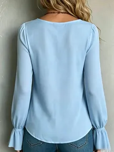 Back view of elegant light blue long-sleeved blouse with pleated shoulders and ruffled cuffs