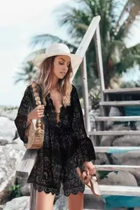 Detail view of black lace beach cover-up with V-neck and flared sleeves on model