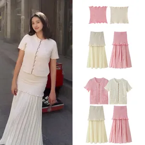 Details van een gebreide set met korte mouwen en plooirok in roze en crème